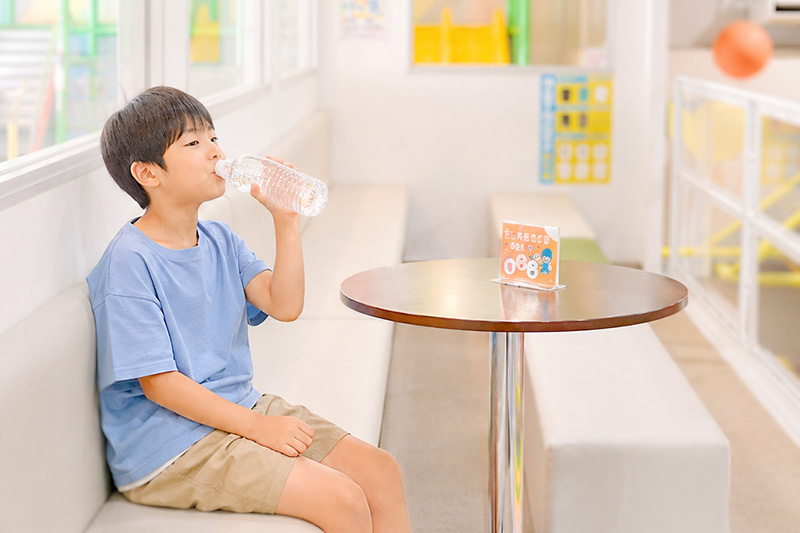 テーブルにお友達と座ってみんなで水を飲みながら会話している画像