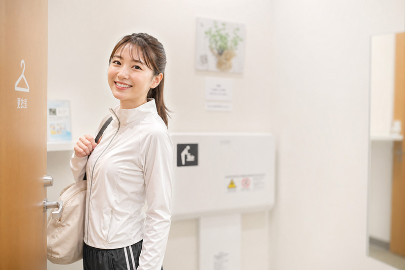 ジャージで更衣室前に立つ女性の画像