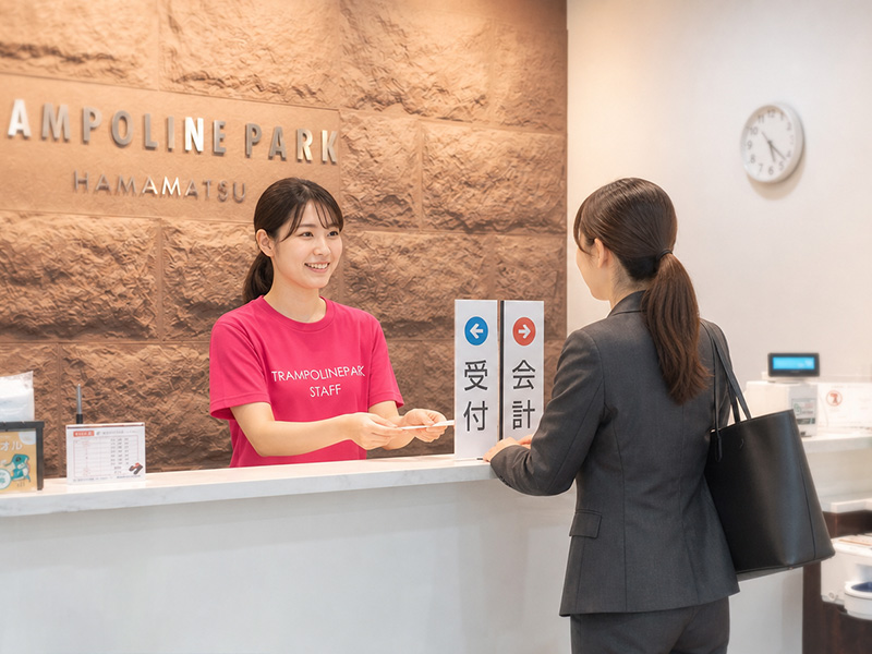 受付で料金明細0円を確認する女性の画像（スーツ姿）